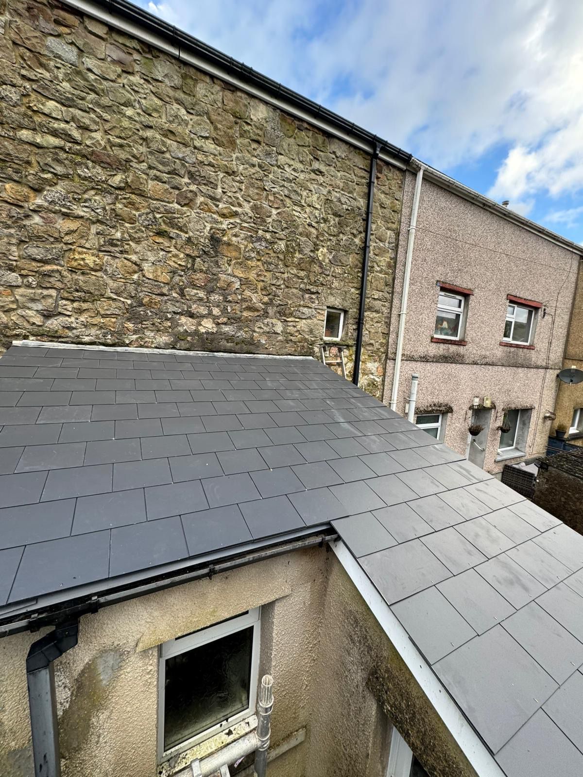 Completed slate roof repair on terraced houses with new guttering in South Wales